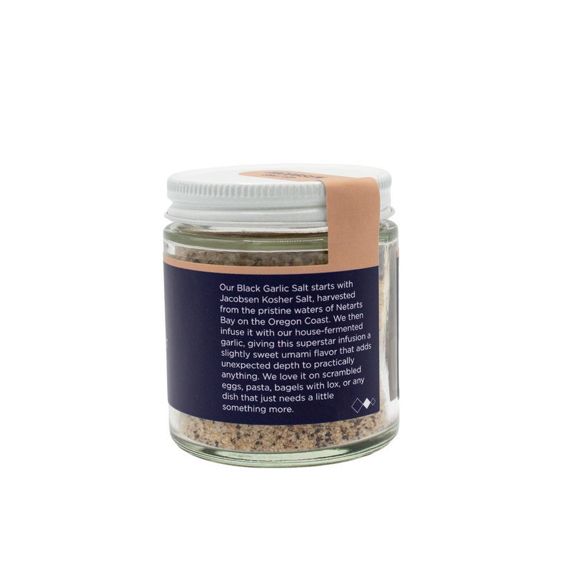 Load image into Gallery viewer, Jacobsen Salt Co. Infused Black Garlic Salt 2.5 oz glass jar with back of label providing information about the salt
