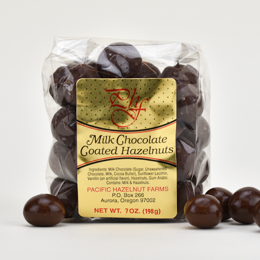 Pacific Hazelnut Farms 7 oz. clear bag of Milk Chocolate Coated Hazelnuts.