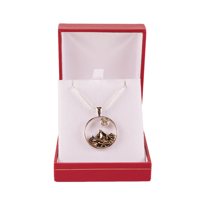 Load image into Gallery viewer, Sterling silver circle pendant with mountain range design and clear 5mm sunstone.
